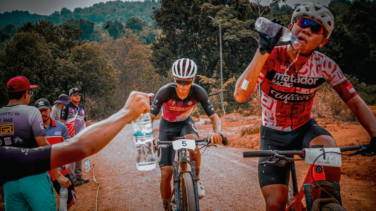 Cyclists hydrate during a strenuous mountain biking race.