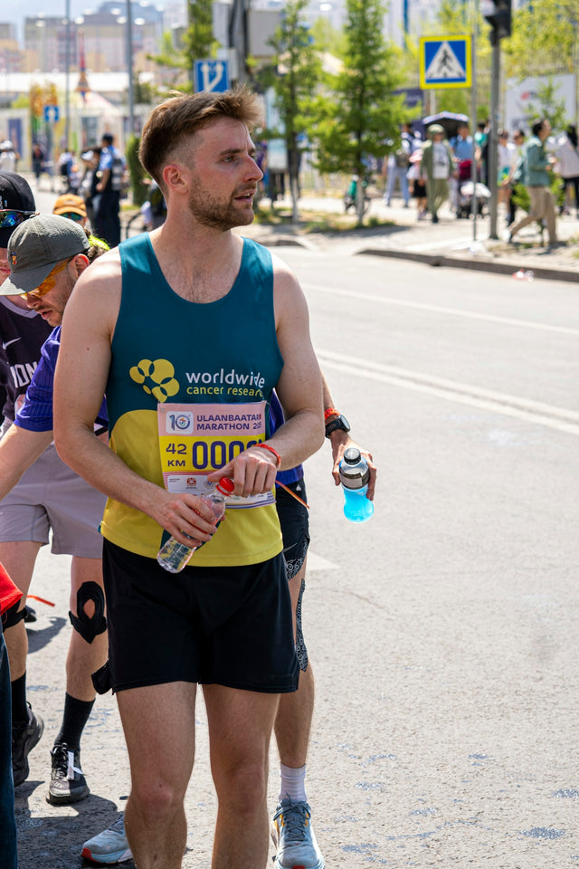 Man in running gear holding water bottle