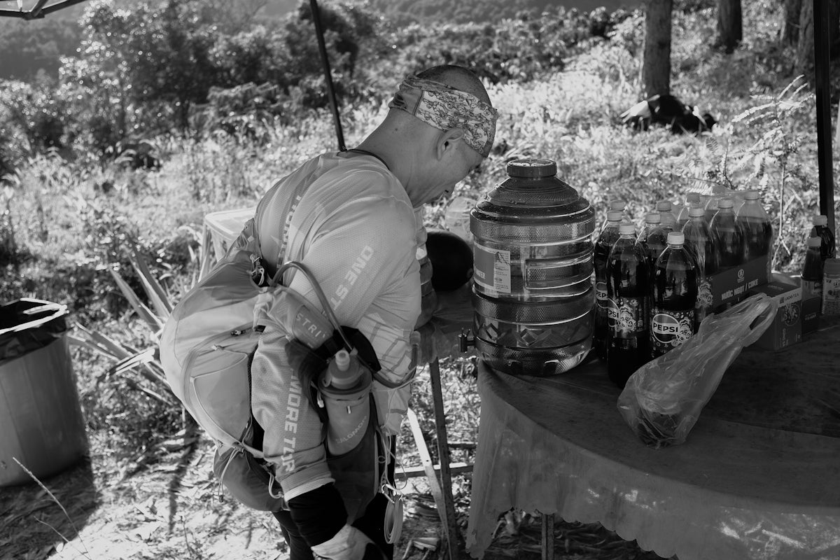 Man with child on back next to bottled drinks